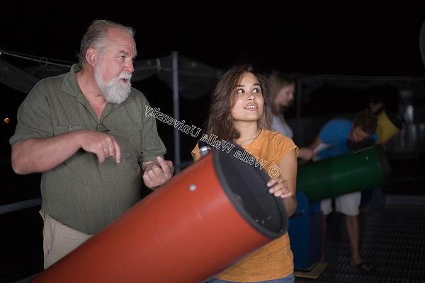 Marty Scott and a student standing by a telescope.